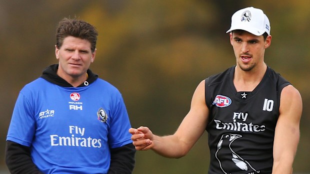 Collingwood assistant coach Robert Harvey looks on as Scott Pendlebury trains.