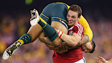 George North of the Lions lifts Israel Folau while carrying the ball during game two of the 2013 Test series against the Wallabies in Melbourne.
