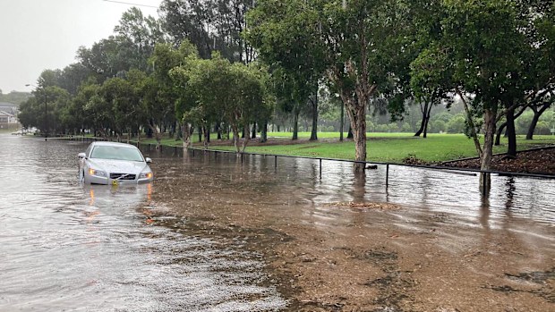 A car is swallowed by water after heavy rain caused flash flooding in Canterbury. 