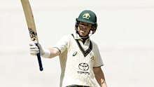 Marcus Harris of Australia A raises his bat after scoring 50 during Australia A and India A's tour match at the MCG.