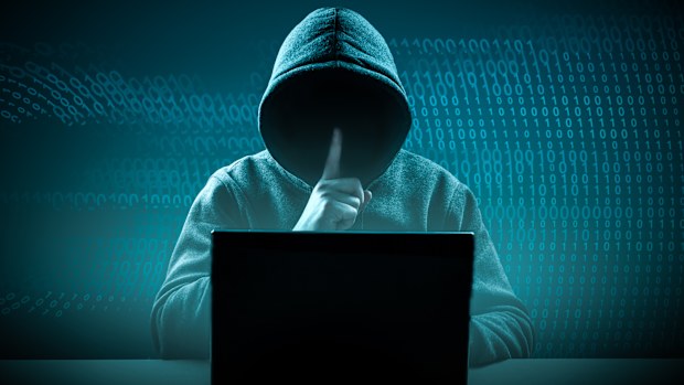 faceless hooded hacker showing silence gesture. Hacker attack. Dangerous Hooded Hacker Breaks into Government Data Servers. Cybersecurity, computer hacker with hoodie. Hacking and malware concept.