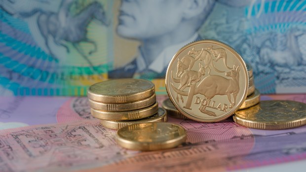 One and Two Dollar Coins Australian ten and five dollar notes in the background - Australian Currency