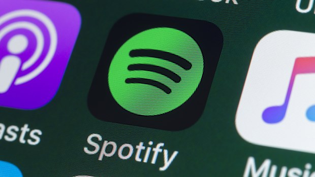 London, UK - July 31, 2018: The buttons of the music streaming app Spotify, surrounded by Podcasts, Apple Music, Facebook and other apps on the screen of an iPhone.