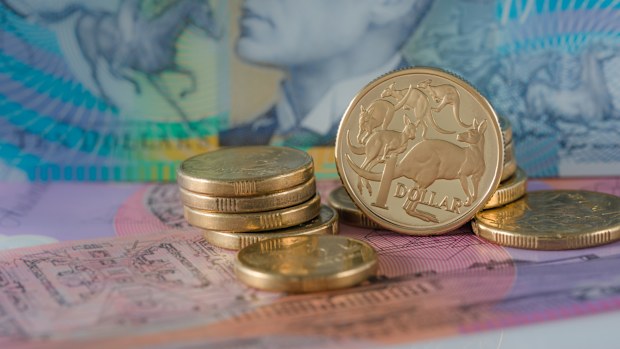 One and Two Dollar Coins Australian ten and five dollar notes in the background - Australian Currency