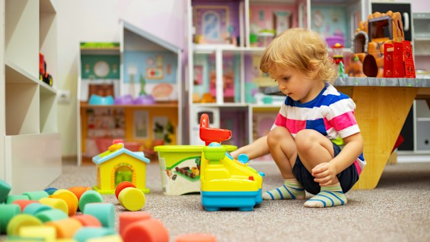 Child playing with colorful toys at daycare / childcare or in kindergarten.