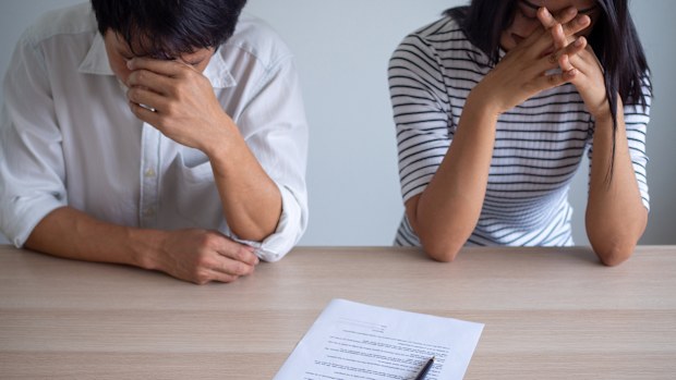 Couple is feeling stressed after agreeing to sign a divorce certificate. Concepts of lovers having family problems, divorce or quarrels or conflicts