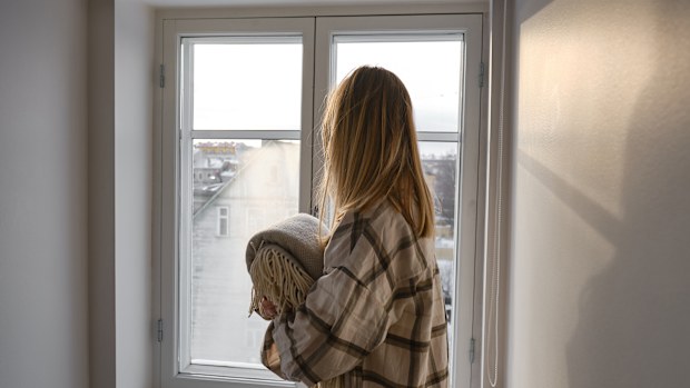 The girl holds a cozy soft blanket in her hands. Warm blanket in the hands of a woman close-up. Winter mood and home textiles