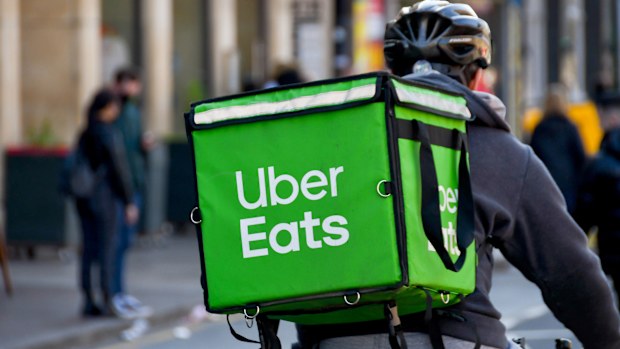 Cardiff, Wales - March 2022: Cycle courier for the Uber Eats food delivery service riding through the city centre