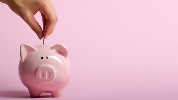 woman hand putting money coin into piggy for saving money wealth and financial concept.
