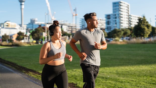 Young Maori couple in casual clothing running outdoor in  Auckland city, New Zealand.