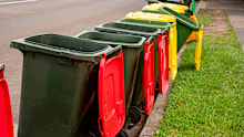 Australian garbage wheelie bins with colourful lids for general and recycling household waste on the street kerbside for council rubbish collection