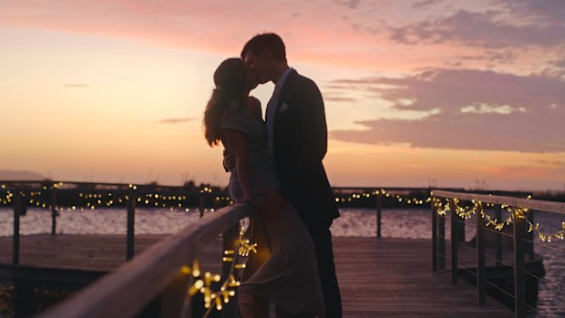 Wedding, love and couple with a kissing bride and groom at sunset with a view on their marriage day. Beautiful sky in the background of a man and woman sharing an intimate kiss after getting married
