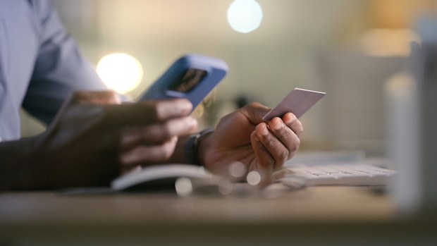 Hands, phone and man with credit card in office for business, startup or loan closeup. Smartphone, zoom and guy manager with online shopping, app or ecommerce, sale or sign up, payment or investment