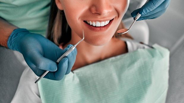 Cropped shot of dentist examining teeth of beautiful female client. Healthy teeth concept.