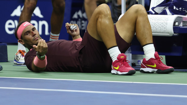 Rafael Nadal of Spain lies on the ground after accidentally hitting himself in the head.