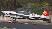 The plane carrying the Peter Brock Trophy hits the wall at Mount Panorama.