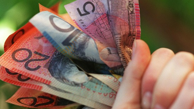 Someone holding a handful of Australian cash.