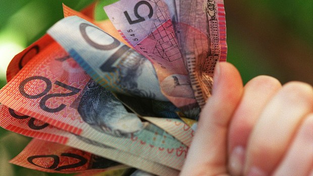 Someone holding a handful of Australian cash.