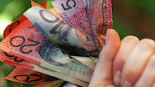 Someone holding a handful of Australian cash.