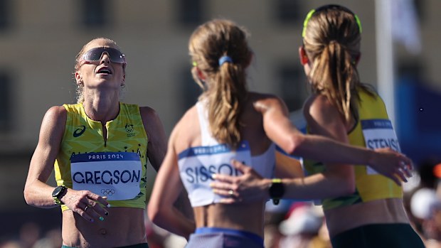 Genevieve Gregson is greeted by the USA's Emily Sisson and Australian teammate Jessica Stenson as she crosses the finish line of the Paris 2024 Olympic Games marathon.