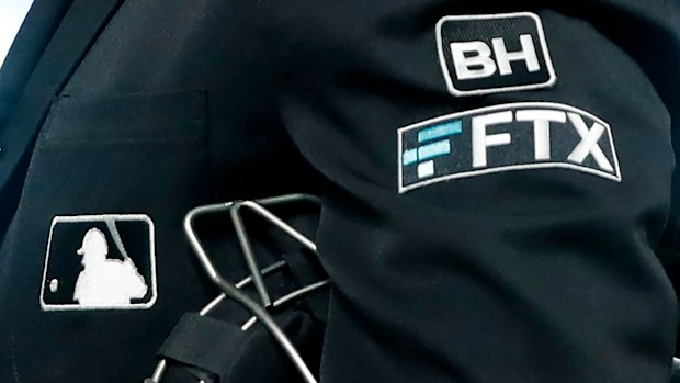 The FTX logo appears on a home plate umpire's jacket at a baseball game with the Minnesota Twins on September 27, 2022, in Minneapolis. The imploding cryptocurrency trading firm FTX is now short billions of dollars after experiencing the crypto equivalent of a bank run. 