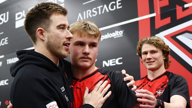 Zach Merrett of the Bombers congratulates Oskar Smartt on his debut.