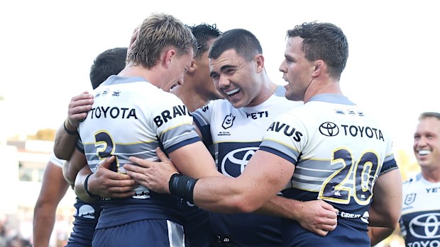 The Cowboys celebrate a try together.