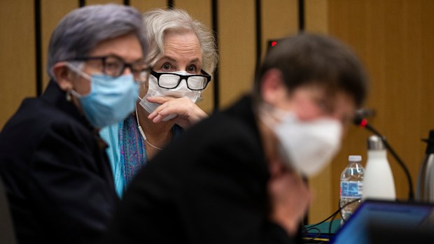 Romance writer Nancy Crampton Brophy, background, accused of killing her husband, Dan Brophy, in June 2018, is surrounded by her defense attorneys in court in Portland.