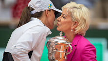 Iga Swiatek is presented her 2023 Roland-Garros trophy by Chris Evert.