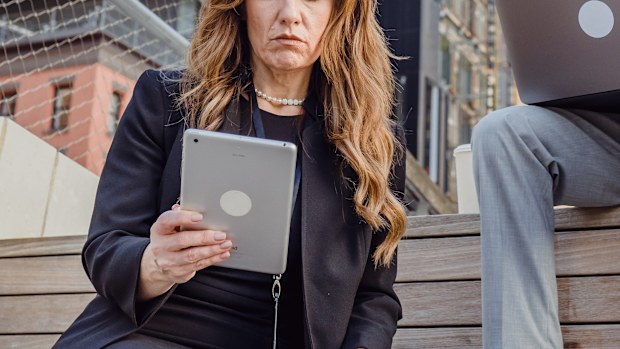 Woman and man working outside on laptop and tablet stock photo.
