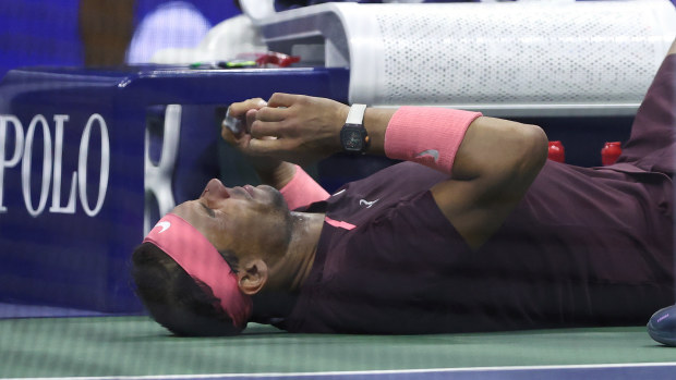 Rafael Nadal of Spain lies on the ground after accidentally hitting himself in the head.