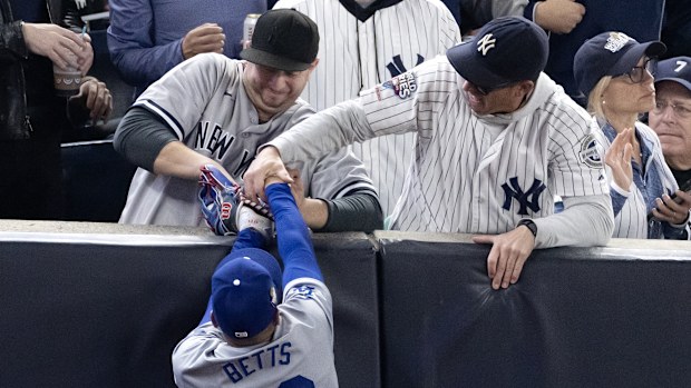 Fans interfere with Mookie Betts #50 of the Los Angeles Dodgers as he attempts to catch a fly ball in foul territory during the first inning of Game Four of the 2024 World Series against the New York Yankees at Yankee Stadium on October 29, 2024 in the Bronx borough of New York City. The play resulted in an out.  (Photo by Al Bello/Getty Images)