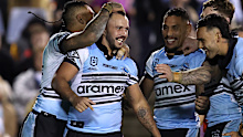 Braydon Trindall of the Sharks celebrates with teammates after scoring a try.