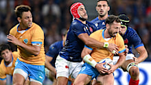 Felipe Berchesi of Uruguay is tackled by Gabin Villiere of France.