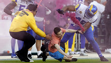 SANTA CLARA, CALIFORNIA - OCTOBER 03: A protester with a smoke bomb is tackled on the field by Los Angeles Rams' Bobby Wagner, #45 Takkarist McKinley #50 and a security guard during their NFL game against the San Francisco 49ers at Levis Stadium in Santa Clara, Calif., on Monday, Oct. 3, 2022. (Jane Tyska/Digital First Media/East Bay Times via Getty Images)