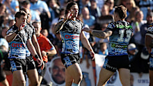 Nicho Hynes celebrates with his Sharks teammates after scoring a try against the Titans.