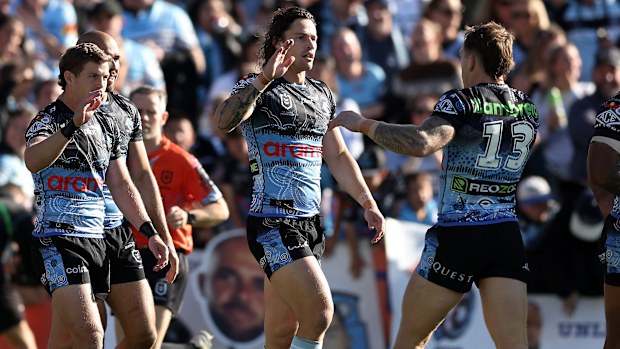 Nicho Hynes celebrates with his Sharks teammates after scoring a try against the Titans.