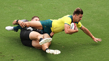 Lachie Anderson of Australia is tackled by Tim Mikkelson of New Zealand.