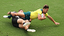Lachie Anderson of Australia is tackled by Tim Mikkelson of New Zealand.