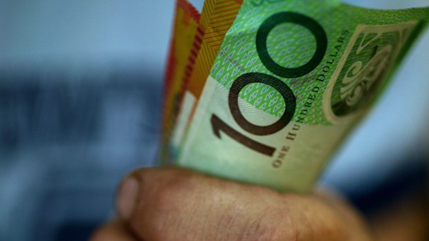 Someone clutching a handful of $50 and $100 notes.