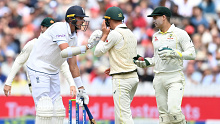 Stuart Broad of England grounds his bat while looking at Marnus Labuschagne and Alex Carey of Australia during day five of the Ashes Test at Lord's.