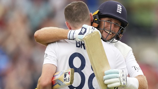 İngiltere'nin Harry Brook, solunda, dördüncü günde yüzlerce koşu attığında İngiltere'nin Joe Root'u tarafından karşılandı.