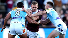 Tom Trbojevic of the Sea Eagles is tackled by the Titans' defense. 