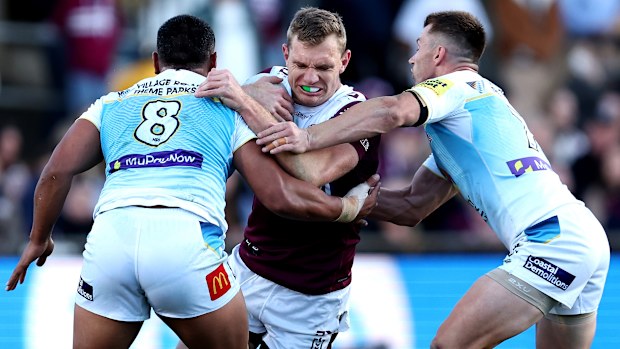 Tom Trbojevic of the Sea Eagles is tackled by the Titans' defense. 