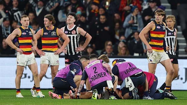 Medal staff assist Izak Rankine of the Crows following an incident with Dan Houston of the Power.