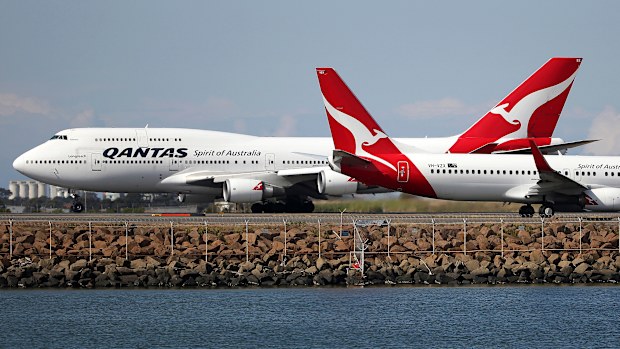 Qantas planes taxi on the runway at Sydney Airport.