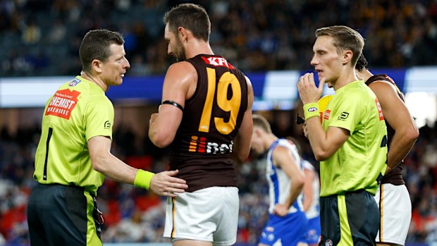 Hawks veteran Jack Gunston speaks with AFL Field Umpires Chris Donlon and Jordan Fry.