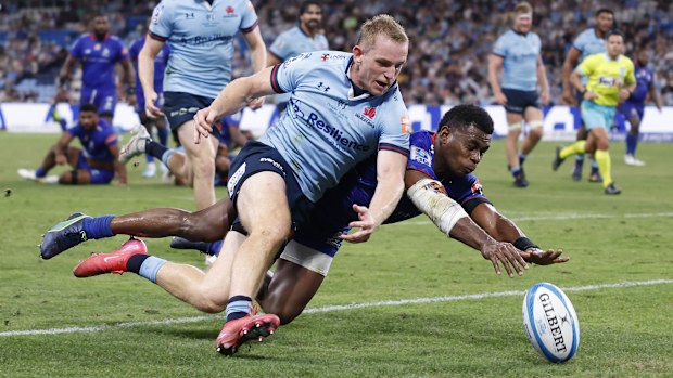 Waratahs' Max Jorgensen pulls off a try-saving tackle on a diving Taniela Rakuro of the Drua.