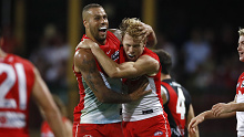 Callum Mills celebrates a goal with Lance Franklin.