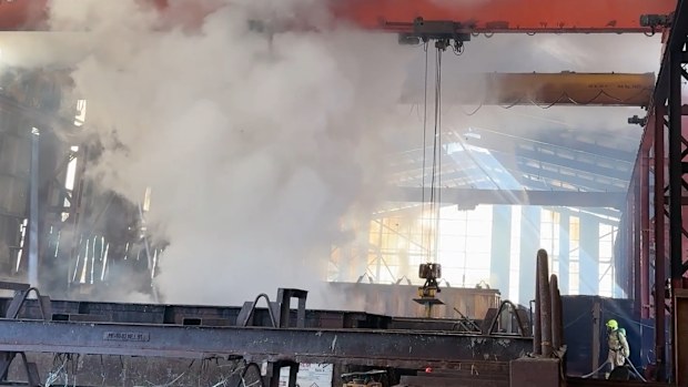 Workers were forced to evacuate a warehouse was engulfed in flames and spewed black smoke over Western Sydney. 